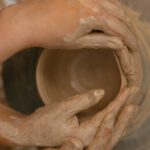 Craft Artists - Muddy Hands Shaping Clay on a Potter's Wheel