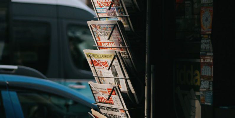 Shopping Hacks - A newspaper rack with a lot of newspapers on it